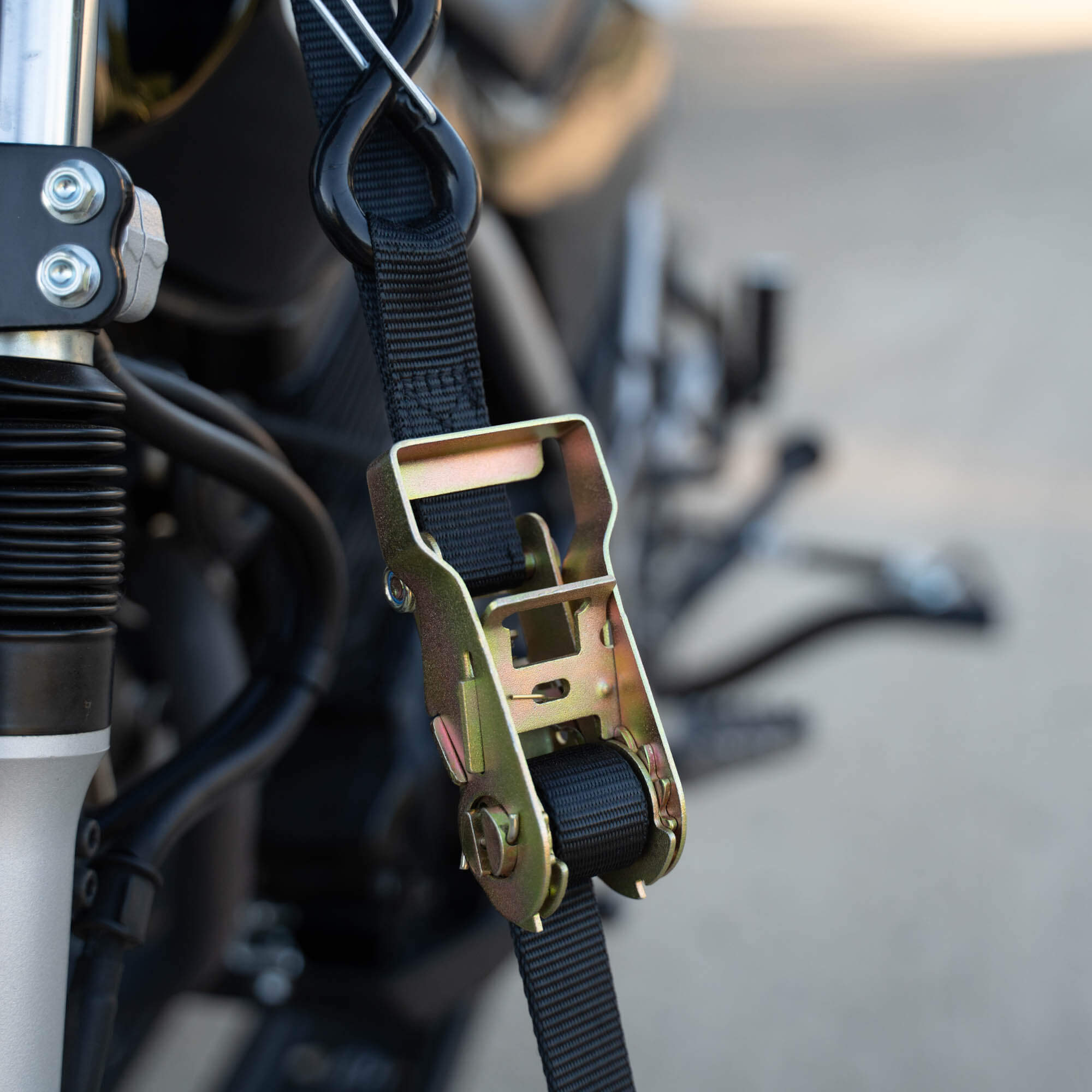 MotoTote SafeLoop ratcheting tie-down system securing a motorcycle with extra holding power and stability for confident motorcycle transport on a hitch carrier.