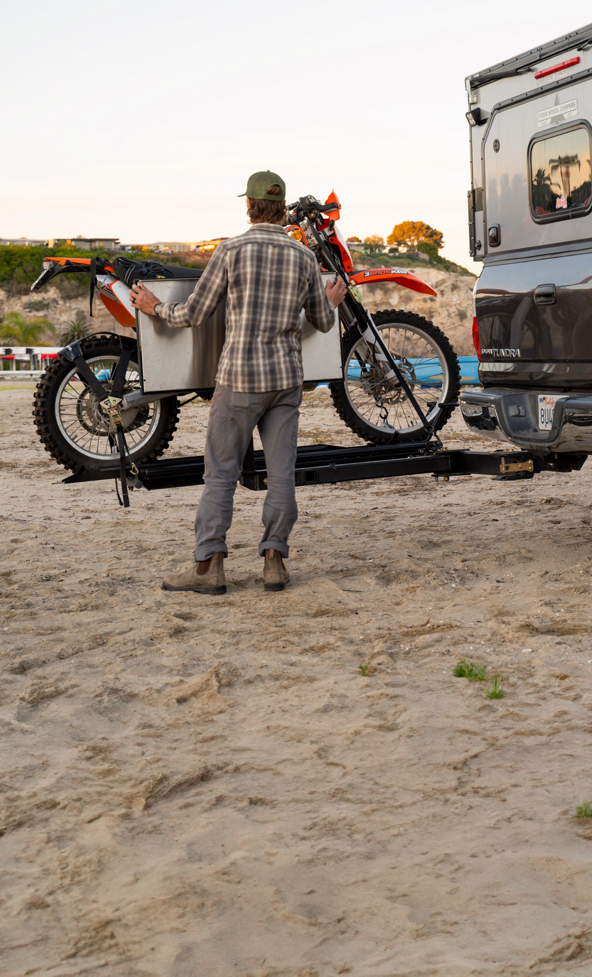 MotoTote M3 motorcycle hitch carrier mounted on a RIGd RambleSwing Pro swing-out hitch system, allowing motorcycles up to 250 lbs to be hauled while maintaining rear vehicle and camper access.