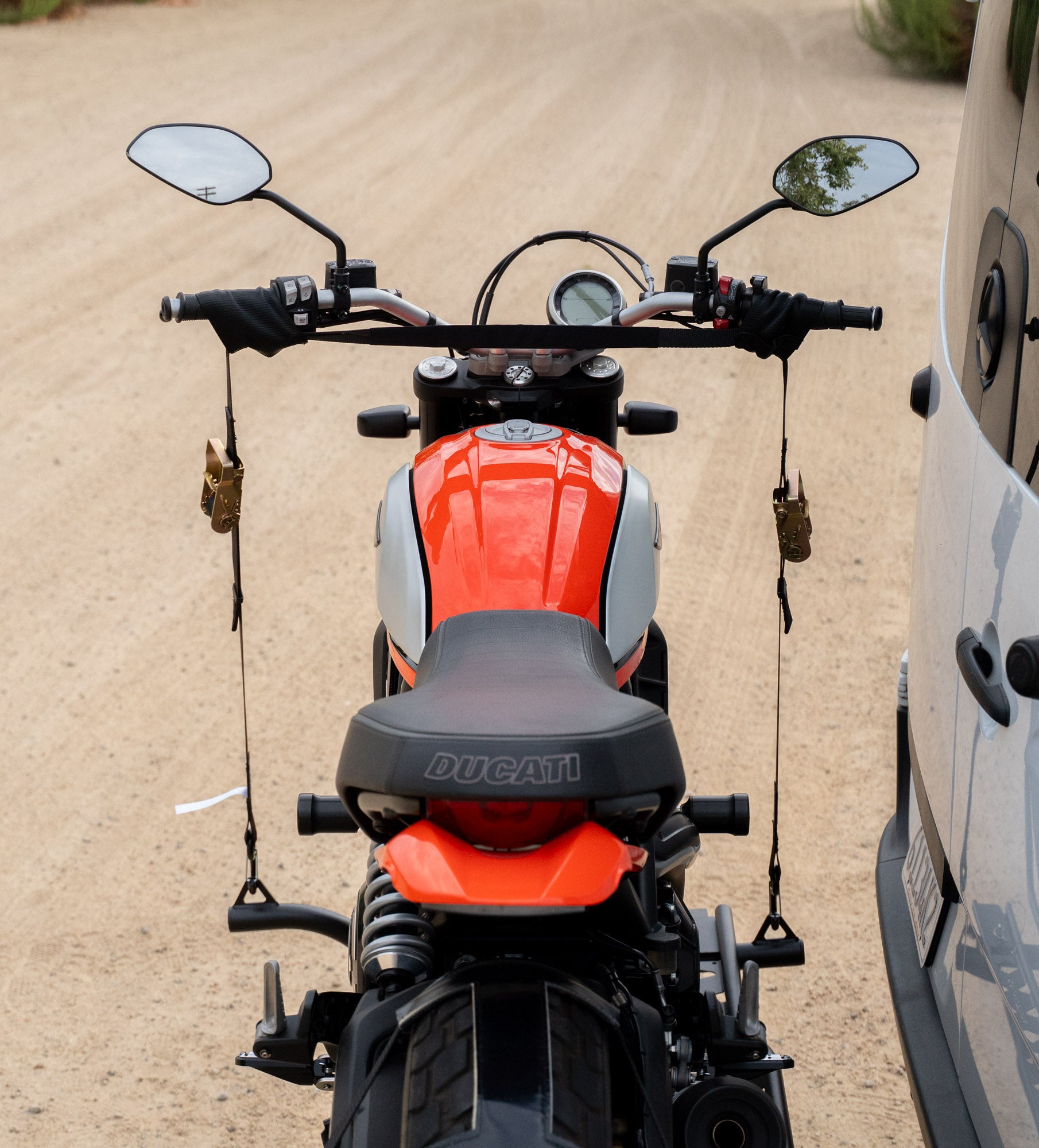 Ducati Scrambler motorcycle secured with MotoTote HandleCuff handlebar tie-downs designed to protect handlebars and bodywork during motorcycle transport without causing damage.