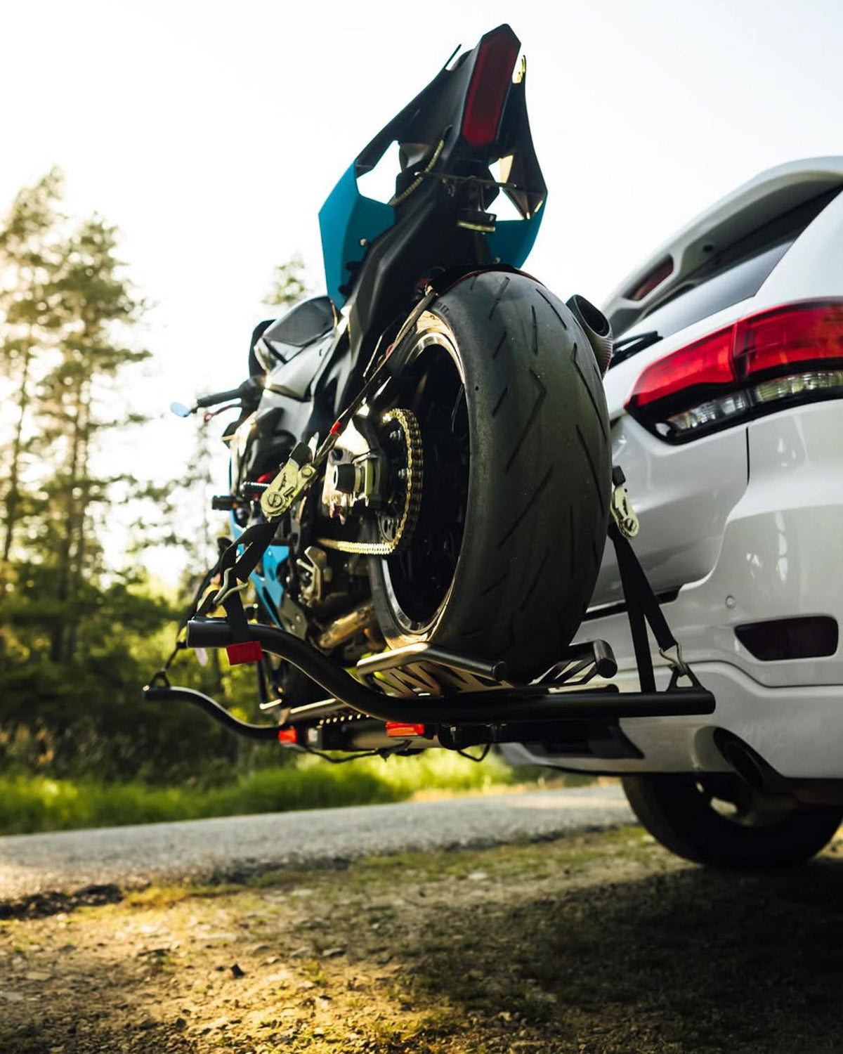 Yamaha R1 sport motorcycle secured on a MotoTote Max+ motorcycle carrier with a MotoTote TireSling rear tire tie-down system for enhanced stability and secure sport bike transport.